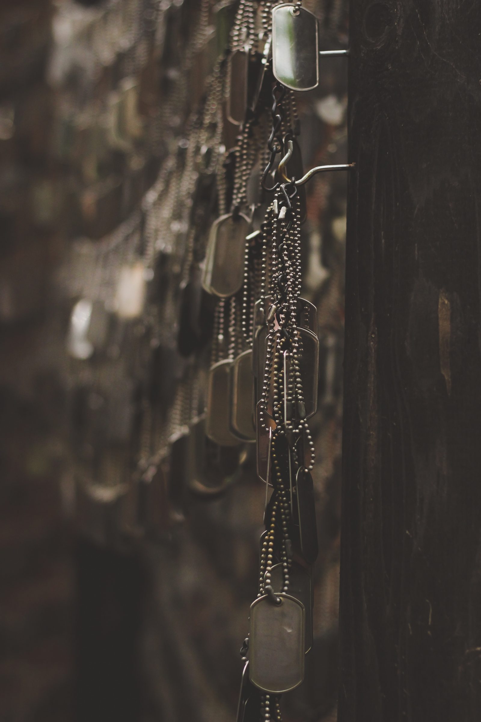 many dog-tags hanging together on a wall
